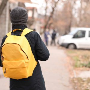 Cute little schoolboy with backpack outdoors